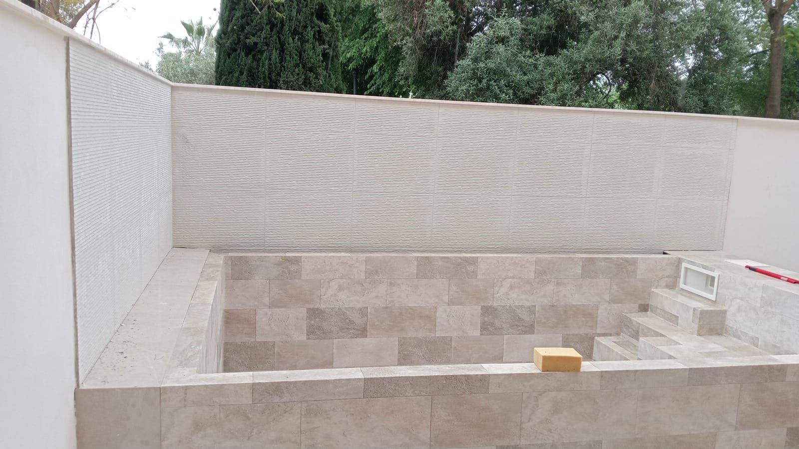 Revestimiento de piedra natural en una terraza exterior reformada en Sevilla